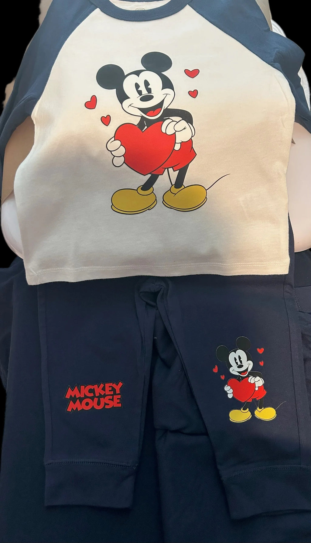 Navy and white shirt with cartoon character holding a heart, paired with navy pants featuring the same character.